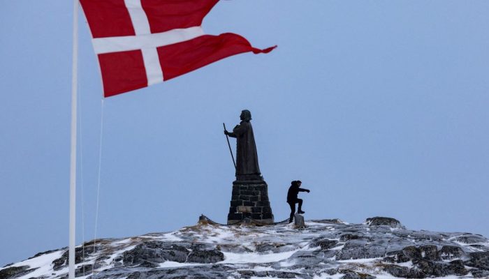 Bandeira da Dinamarca tremula ao lado da estátua de Hans Egede em Nuuk, Groenlândia  • 09/03...