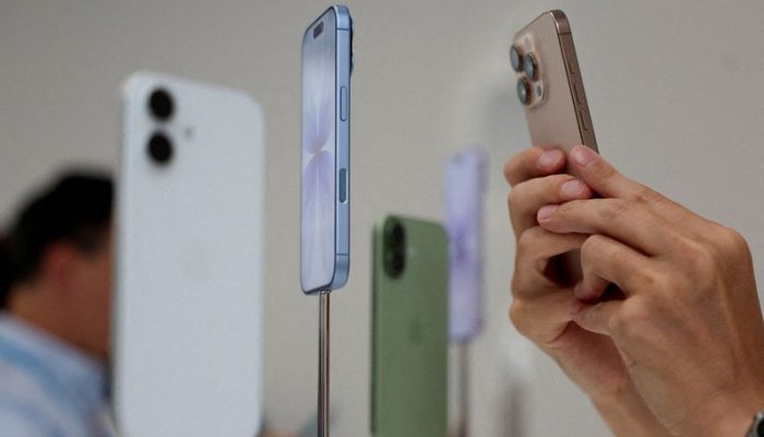 Evento da Apple em Cupertino  • Uma pessoa usa um telefone para fotografar iPhones em exposiç...